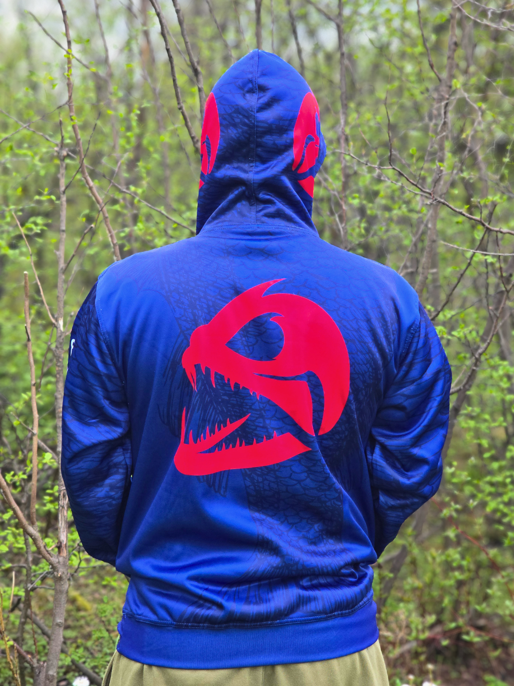 Vue arrière du hoodie de pêche bleu Les Cannes Boréal avec grand logo rouge au dos et motif de poisson intégré.